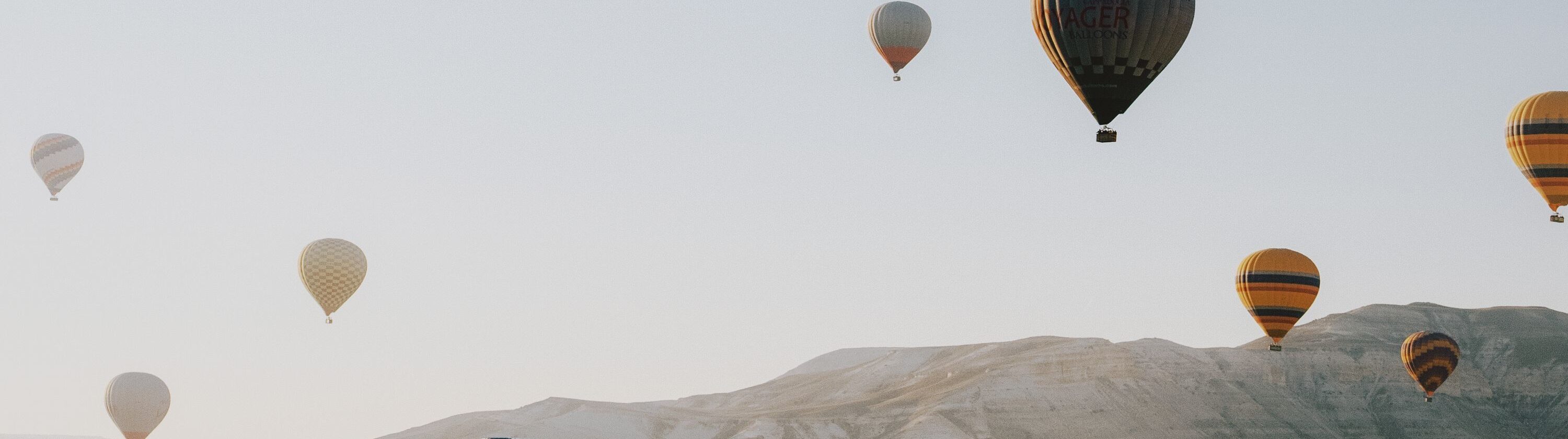 Colorful hot air balloons floating over the Cappadocia landscape in Turkey