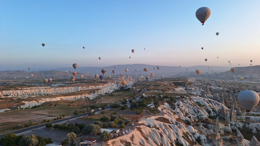 Hot air balloons floating over the valleys and rock formations of Cappadocia, Turkey at sunrise