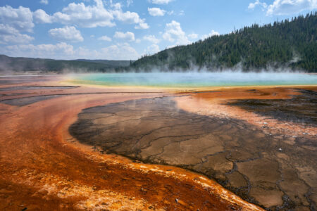 Orange microbial mats surrounding steaming turquoise water at Grand Prismatic Spring in Yellowstone
