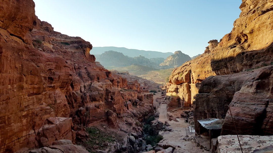Travelers hiking through the sandstone canyon toward the Monastery at Petra, Jordan