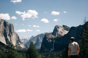 Traveler overlooking Yosemite Valley from Tunnel View with El Capitan, Bridalveil Fall, and Half Dome