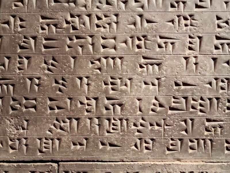 Close-up of ancient cuneiform script carved across a stone surface