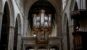 Historic English church interior with stone arches, timber ceiling, organ, and central aisle
